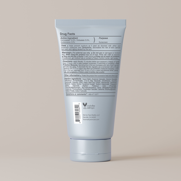 Back view of a blue sunscreen tube with text on a beige background