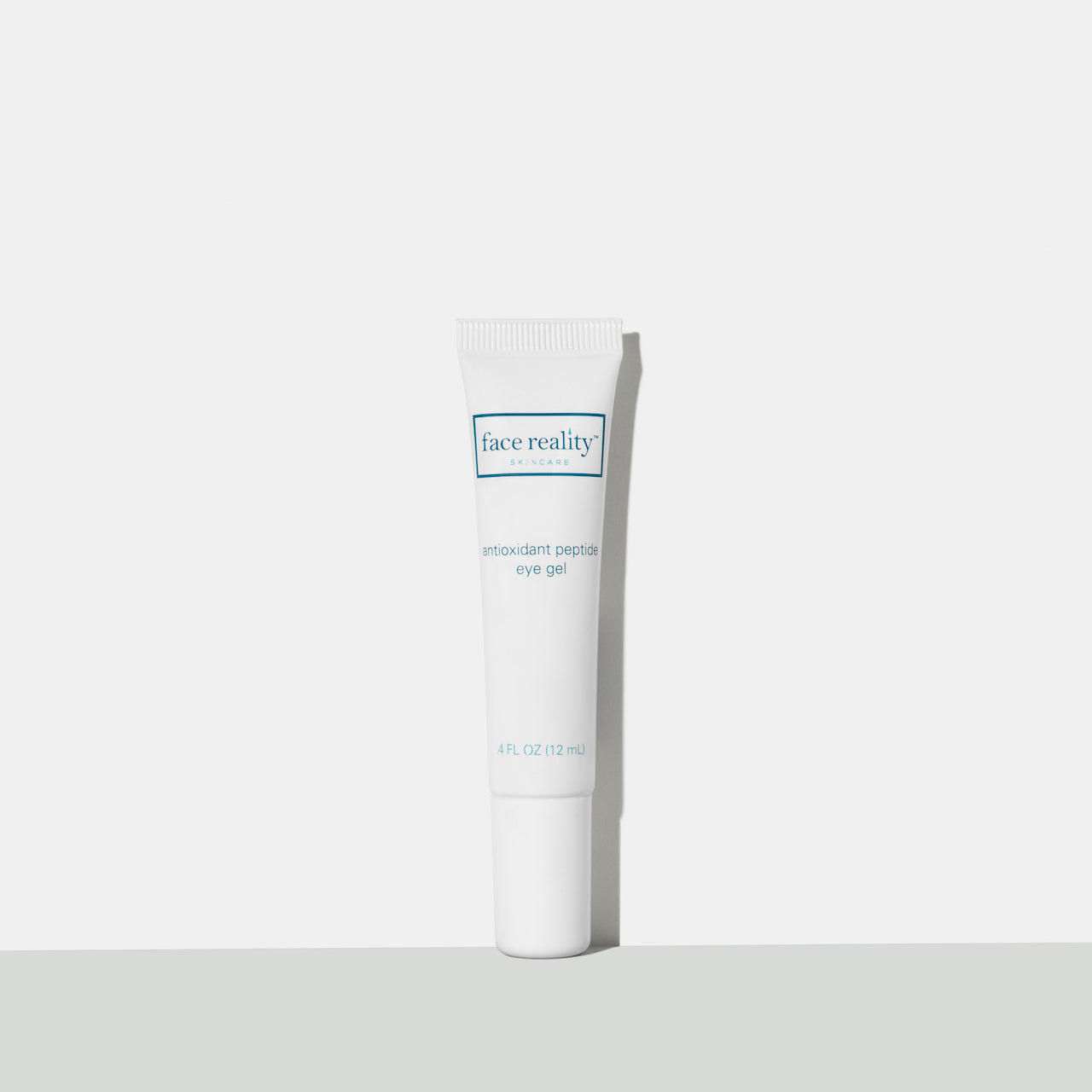White point 4 fluid ounce tube of antioxidant peptide eye gen in front of a white background on a grey surface