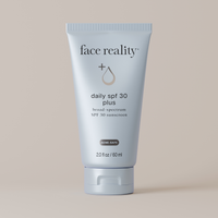 Tube of face reality daily SPF 30 plus sunscreen on a beige background