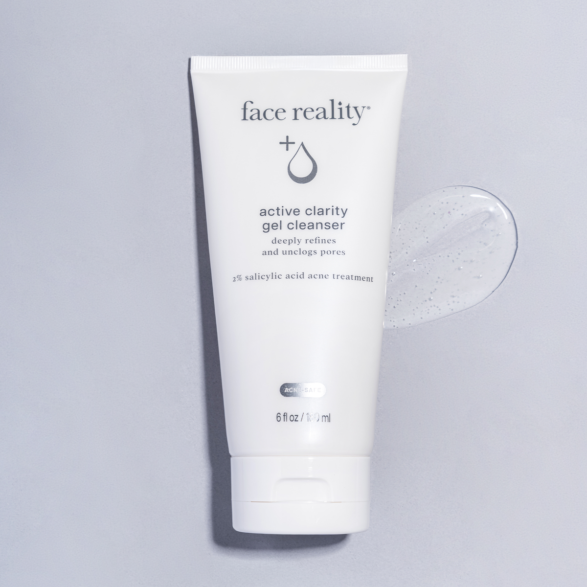 Tube of active clarity gel cleanser laying flat against gel swatch on a light gray background. 