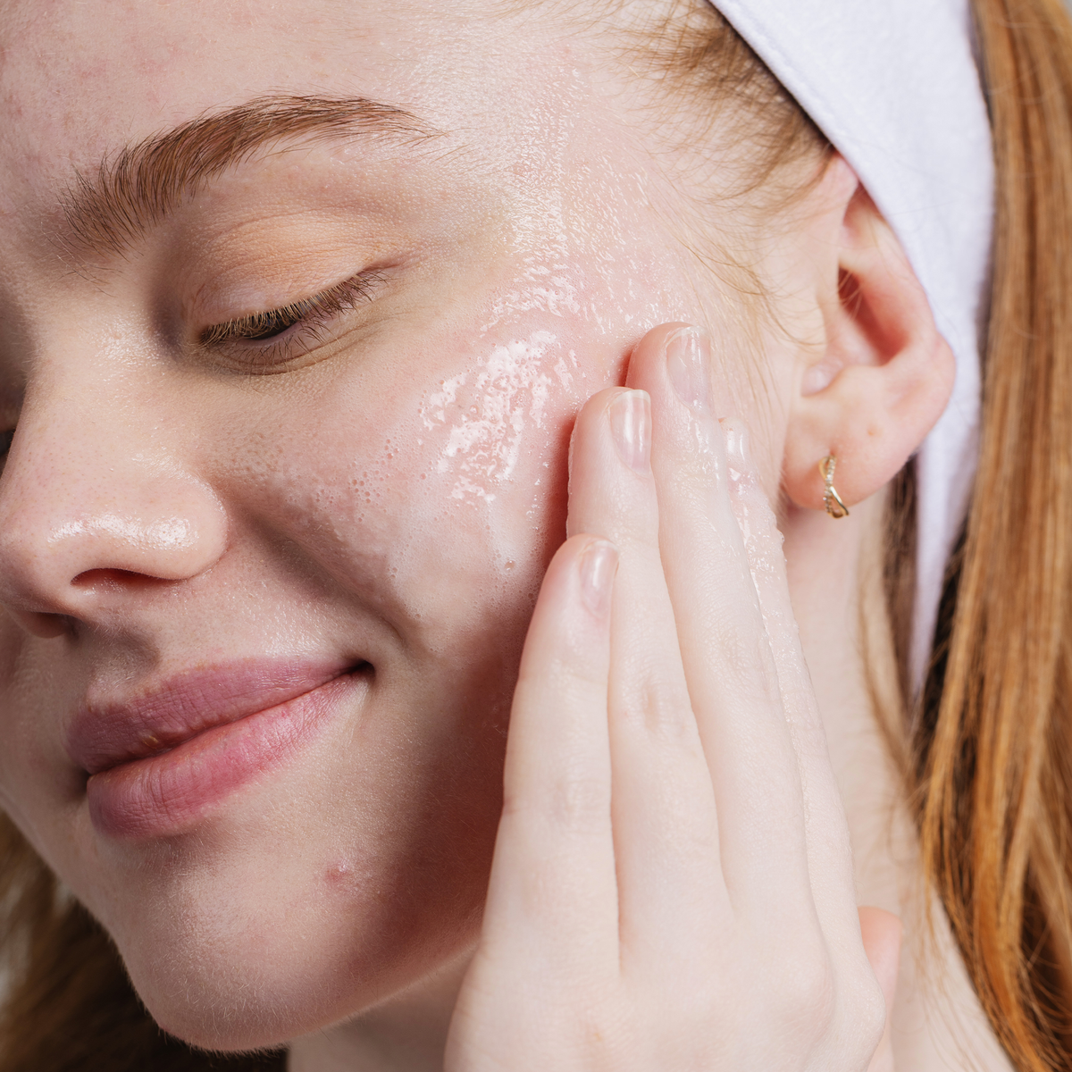 Close up of a person applying active clarity gel cleanser on to their face. 