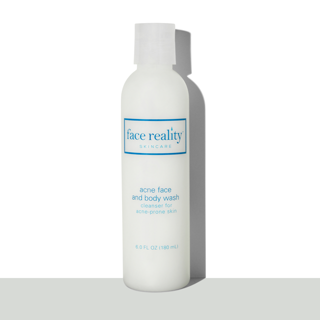 Clear six ounce bottle of Face Reality acne face and body wash in front of a white background on a grey surface  - view 1