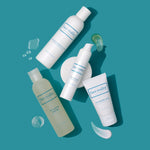 Artistic image of 6 oz bottles of Face Reality Ultra Gentle Cleanser and Moisture Balance Toner next to a white one point seven ounce bottle of hydrabalance hydrating gel and a white two ounce bottle of cran peptide cream on a teal background  - view 2